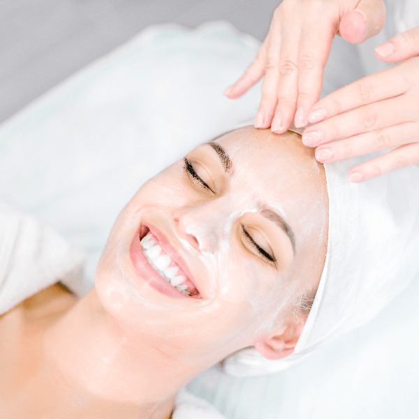 Woman receiving a sea salt facial treatment, targeting fine lines, wrinkles, enlarged pores, acne, uneven pigmentation, and scarring for enhanced skin appearance.